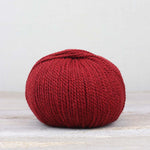 A single ball of The Fiber Co. &Make Aran in color Cherries & Berries