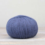 A single ball of The Fiber Co. &Make Aran in color Prince