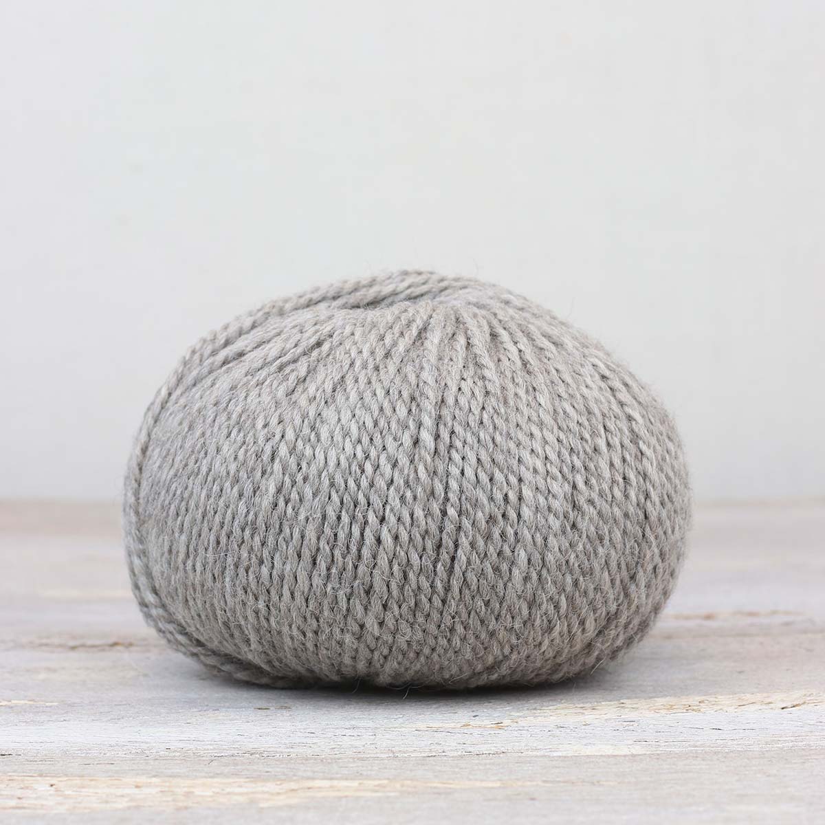 A single ball of The Fiber Co. &Make Aran in color Silver Screen