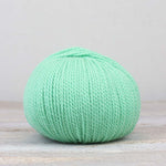 A single ball of The Fiber Co. &Make Aran in color Spearmint